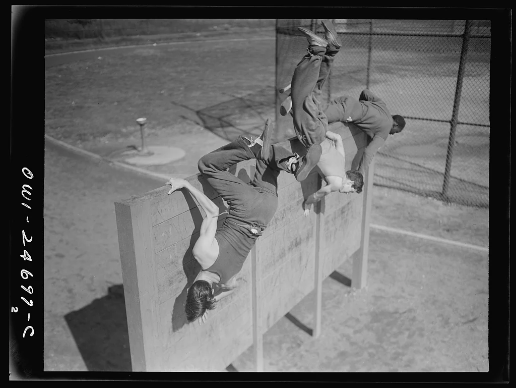 Jóvenes superan un muro durante un ejercicio físico en una fotografía histórica de 1942.
