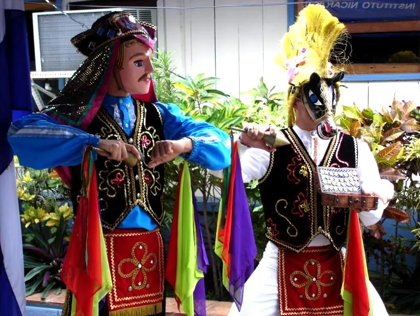 Personajes con vestuario y máscaras en una representación de El Güegüense