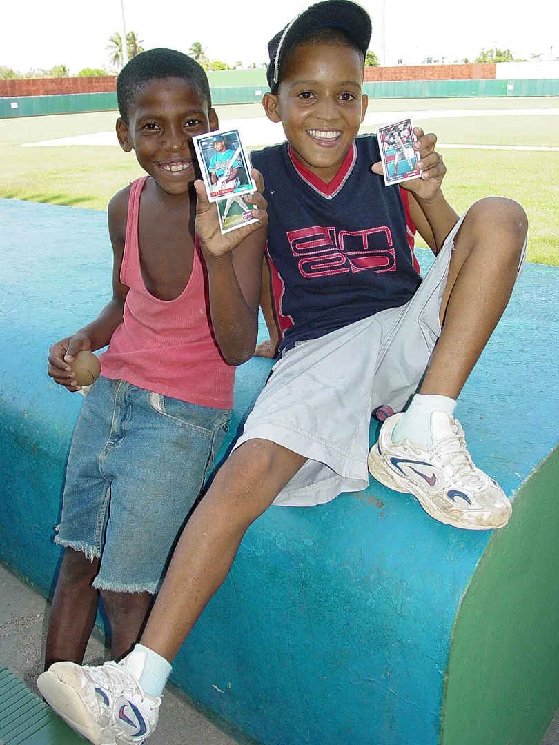 Niños con tarjetas de béisbol en un estadio de San Pedro de Macorís