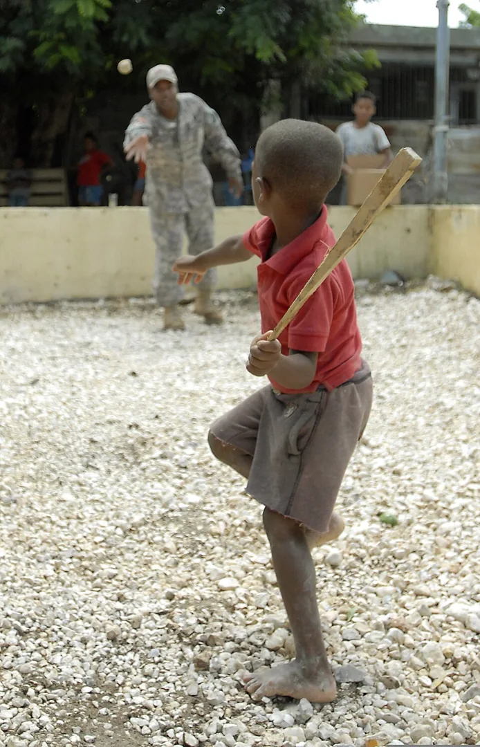 Un niño participa en un juego de bate y pelota improvisada en Vicente Noble en 2014